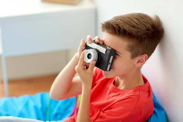 Menino feliz com câmera de filme fotografando em casa — Fotografia de Stock