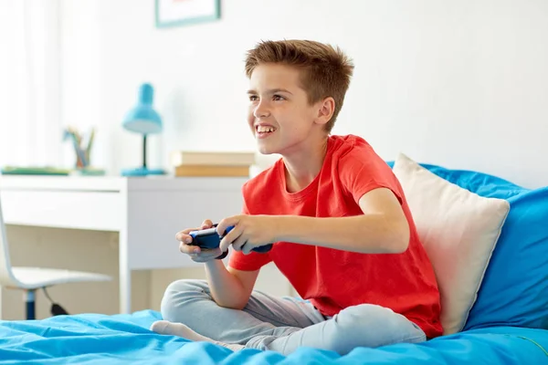 Niño feliz con gamepad jugando videojuego en casa — Foto de Stock