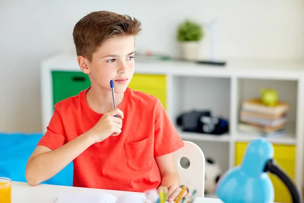 A toll és jegyzetfüzet gondolkodás otthon tanuló fiú — Stock Fotó