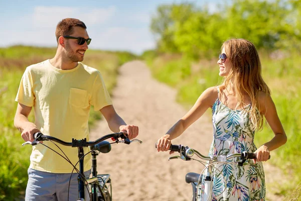 Feliz pareja con bicicletas en el camino del campo —  Fotos de Stock