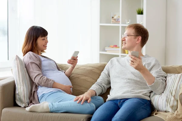 남편과 집에서 스마트폰으로 임신 아내 — 스톡 사진