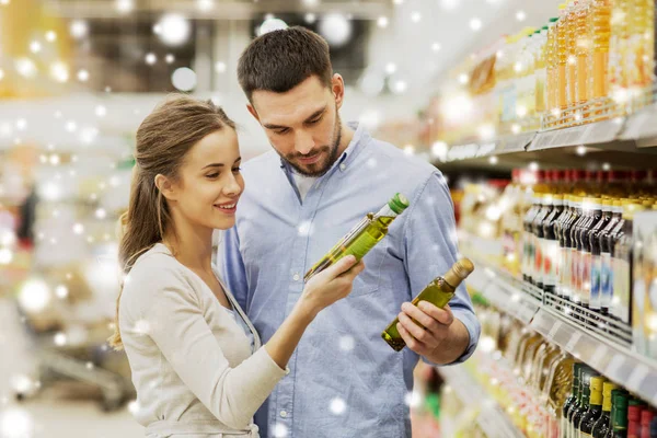 Heureux couple achetant de l'huile d'olive à l'épicerie — Photo