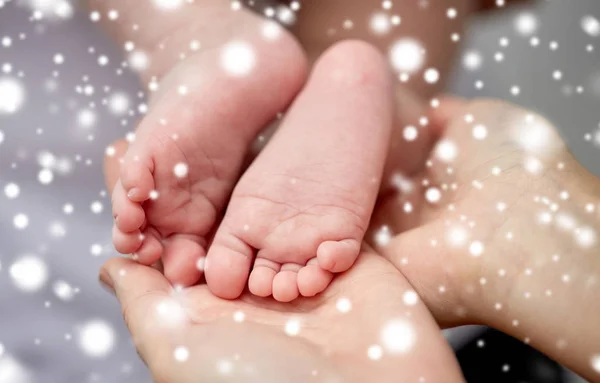 Κοντινό πλάνο του νεογέννητου μωρού πόδια στα χέρια της μητέρας — Φωτογραφία Αρχείου
