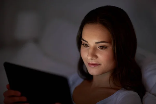 Jeune femme avec tablette PC dans le lit à la maison chambre — Photo