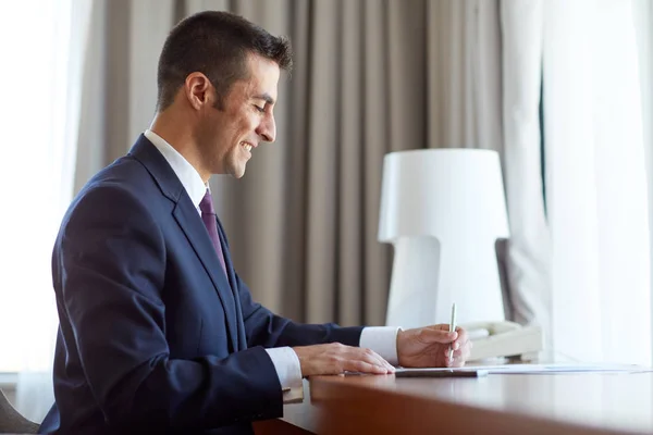 Homme d'affaires avec papiers travaillant à la chambre d'hôtel — Photo