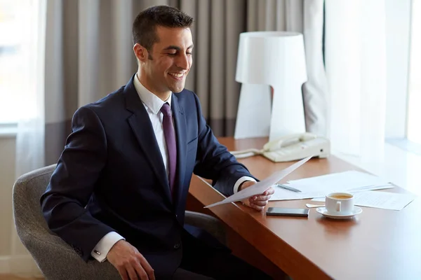 Бизнесмен с документами, работающий в гостиничном номере — стоковое фото