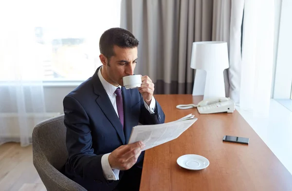 Geschäftsmann liest Zeitung und trinkt Kaffee — Stockfoto