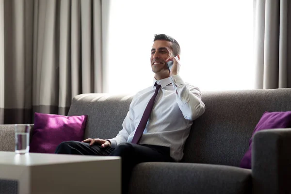 Empresário chamando no smartphone no quarto de hotel — Fotografia de Stock