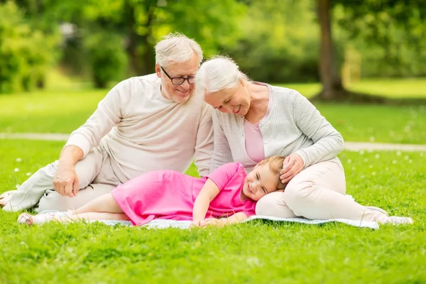 Senior morföräldrar och barnbarn på park — Stockfoto