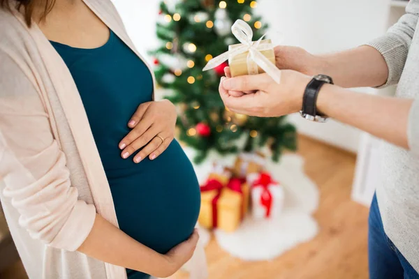 Echtgenoot van geven kerstcadeau aan zwangere vrouw — Stockfoto