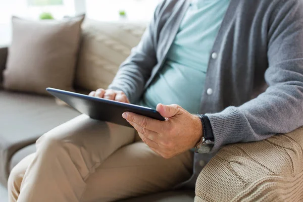 Close up of senior man with tablet pc on sofa — Stock Photo, Image