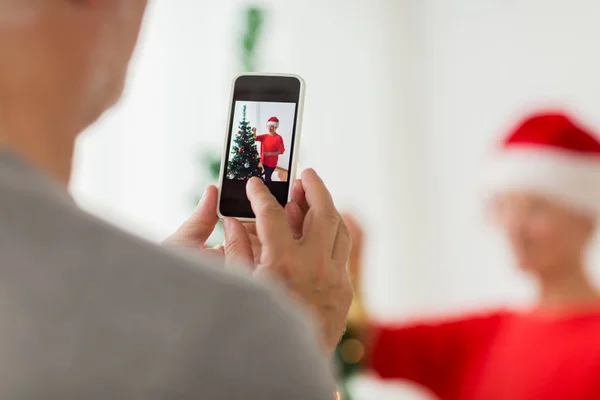 Close up of senior man picturing wife at christmas — Stock Photo, Image