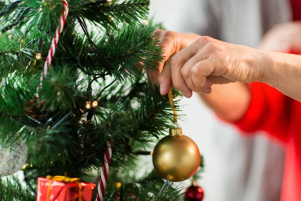 Primer plano de la mujer mayor que adorna el árbol de Navidad — Foto de Stock