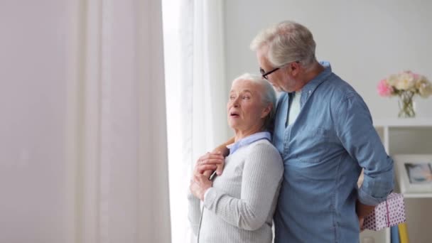 Gelukkige senior paar met de gift van de verjaardag thuis — Stockvideo