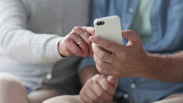 Щаслива старша пара зі смартфонами вдома — стокове відео