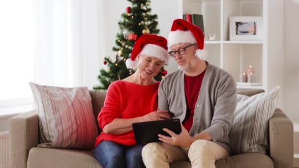 Happy senior couple with tablet pc at christmas — Stock Video