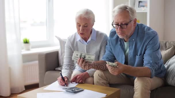Пожилая пара с деньгами и счетами дома — стоковое видео