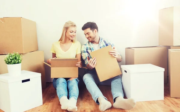 Sonriente pareja con muchas cajas mudándose a un nuevo hogar —  Fotos de Stock