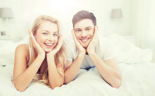 Feliz pareja acostada en la cama en casa —  Fotos de Stock