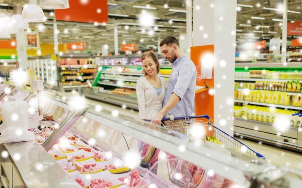 Met het winkelwagentje kopen van vlees bij supermarkt (echt) paar — Stockfoto
