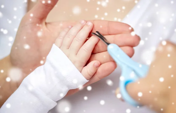 Primer plano de la mano con tijeras recortar las uñas del bebé — Foto de Stock