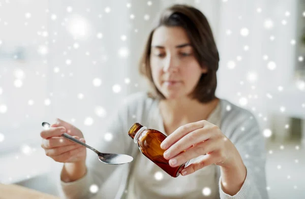 Ill woman pouring medication from bottle to spoon — Stock Photo, Image