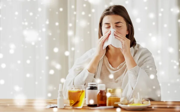 Zieke vrouw met medicijnen snuit neus af te vegen — Stockfoto