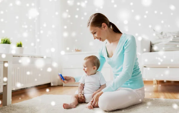 Glückliche Mutter zeigt Baby zu Hause Smartphone — Stockfoto