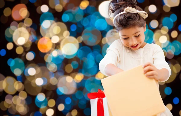 Sorridente bambina con scatola regalo sopra le luci — Foto Stock