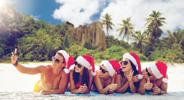 Group of friends in santa hats with taking selfie — Stock Photo, Image