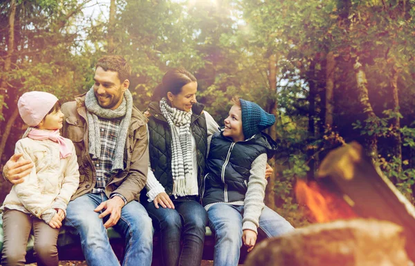 Famiglia felice seduta sulla panchina al fuoco del campo — Foto Stock