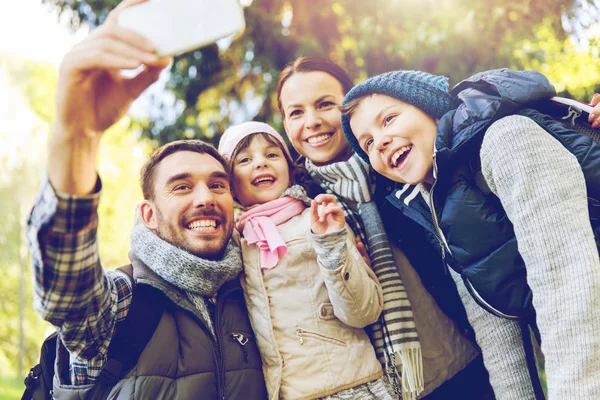 Rodziny z plecakami biorąc selfie przez smartfona — Zdjęcie stockowe