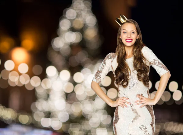 Happy woman in crown over christmas tree lights — Stock Photo, Image