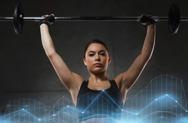 헬스 클럽에서 바 벨으로 근육을 flexing 젊은 여자 — 스톡 사진