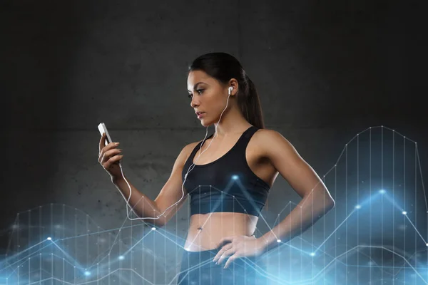 Mujer con smartphone y auriculares en el gimnasio —  Fotos de Stock