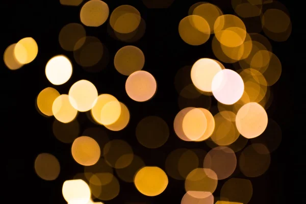 Luzes douradas borradas sobre fundo escuro — Fotografia de Stock