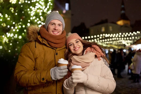 Heureux jeune couple avec café au marché de Noël — Photo