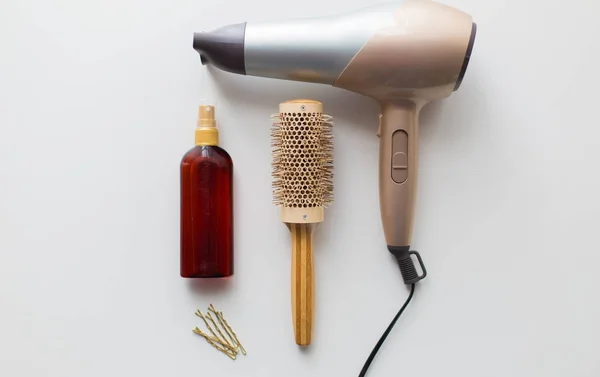 Hairdryer, brush, hot styling hair spray and pins — Stock Photo, Image
