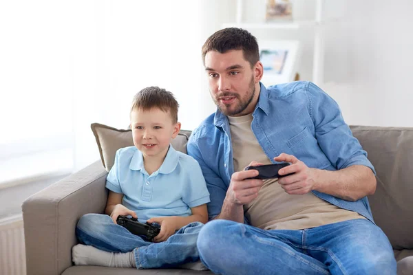 Pai e filho jogando videogame em casa — Fotografia de Stock