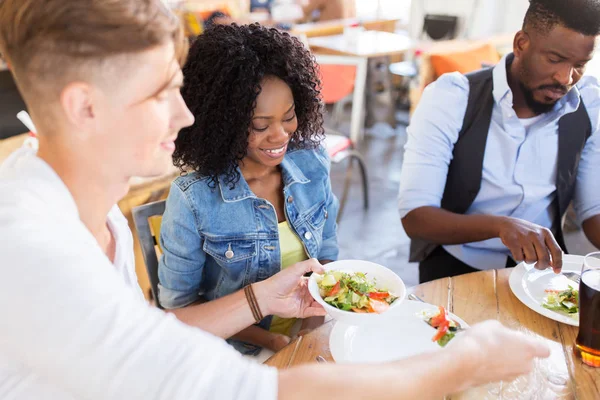 Glückliche Freunde essen und reden im Restaurant — Stockfoto