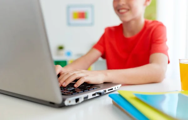 Студентський хлопчик друкує на ноутбуці вдома — стокове фото