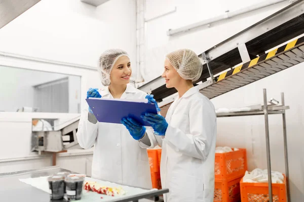 Mujeres tecnólogos degustación de helado en la fábrica — Foto de Stock