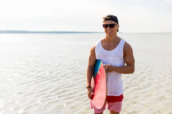 Glücklicher junger Mann mit Skimboard am Sommerstrand — Stockfoto