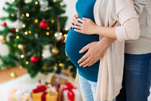 Man och gravid kvinna hemma vid jul — Stockfoto