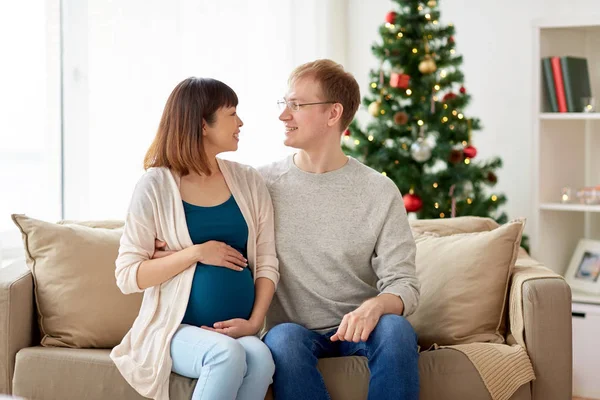 Gravida fru med make hemma vid jul — Stockfoto