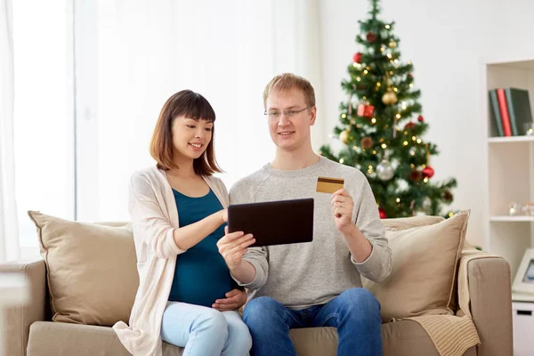 Mann und schwangere Frau kaufen zu Weihnachten online ein — Stockfoto