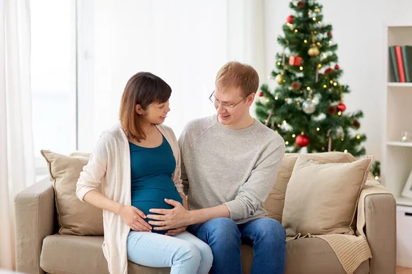 Pregnant wife with husband at home at christmas — Stock Photo, Image