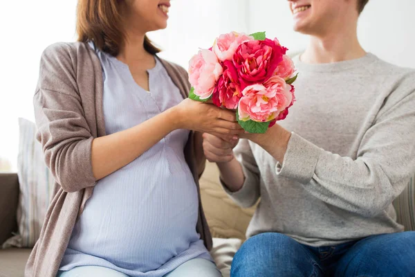 Zbliżenie na człowieka, daje kwiaty do żony w ciąży — Zdjęcie stockowe