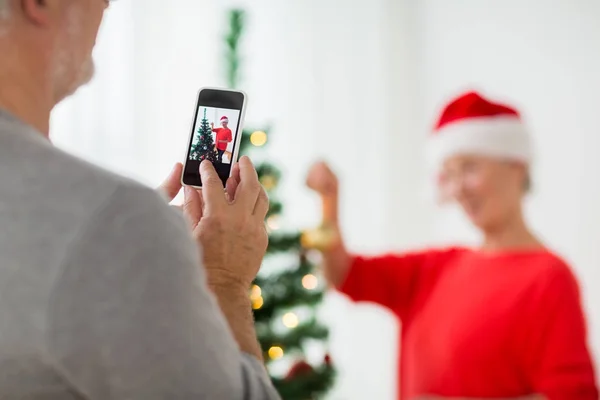 Nahaufnahme eines älteren Mannes, der Frau an Weihnachten fotografiert — Stockfoto