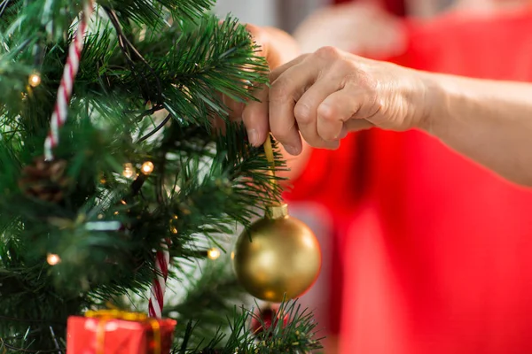 Primer plano de la mujer mayor que adorna el árbol de Navidad — Foto de Stock